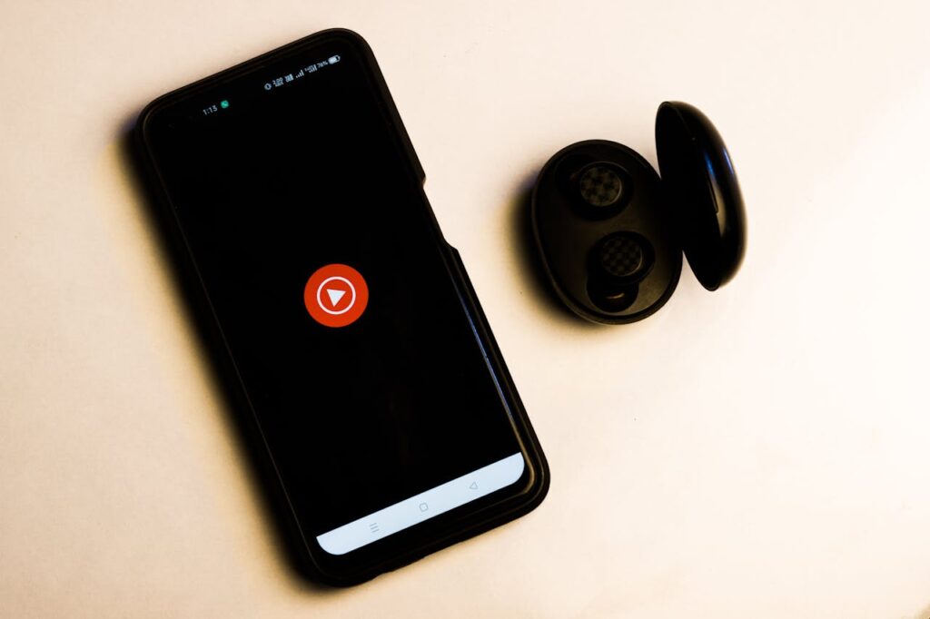 pexels photo 16587507 Flat lay of a smartphone and wireless earbuds on a neutral background, ideal for tech and lifestyle themes.